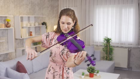 Inspirational-talented-musician-woman-playing-violin-at-home-and-happy.